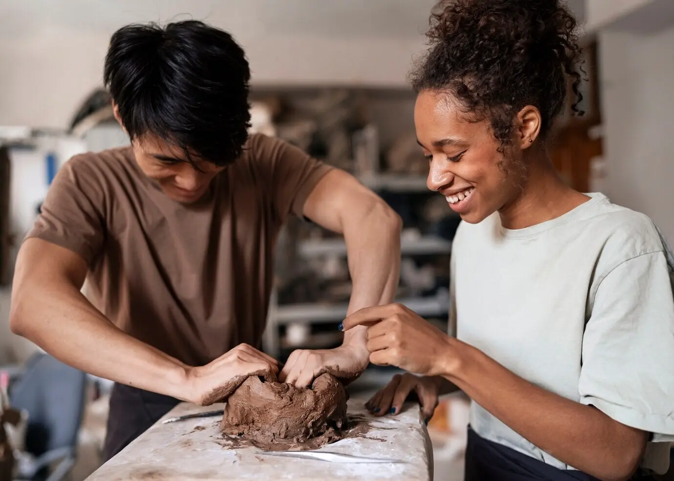 Frontalansicht von lächelnden Menschen beim Modellieren mit Ton.
